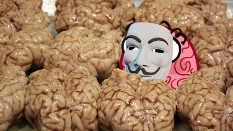 Jar brain hiding behind a Fawkes mask in a crowd of brains