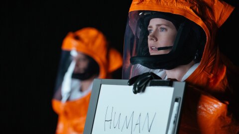 Human in a hazmat suit with a whiteboard Arrival movie backdrop