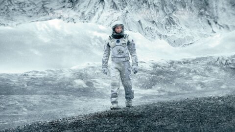 Interstellar Matthew McConaughey in a spacesuit on an icy planet movie backdrop