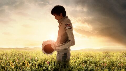 Asa Butterfield standing in a spacesuit in a field on Earth, Space Between Us movie backdrop